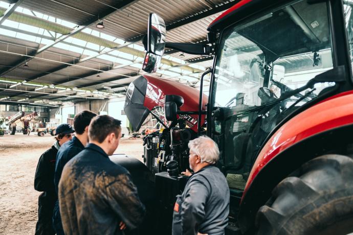 Studenten Agro- en biotechnologie bij een tractor